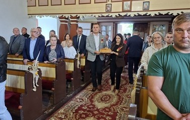 Starostowie Dożynek niosą chleb w darach 