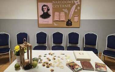 Przygotowane miejsce do czytania Narodowego Dzid&oacute;w, w tle gazetka ścienna 