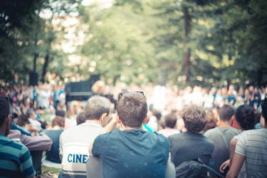 Koncert muzyki filmowej. Tłum ludzi siedzący na trawniku.