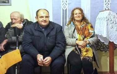 Mężczyzna i kobieta siedzą podczas mszy w świetlicy w Stojpach