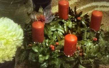 Wieniec z kwiat&oacute;w z czterema świecami