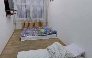 oświetlone pomieszczenie, na podłodze dwa materace z pościelą