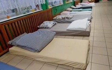 korytarz z materacami i pościelą do spania