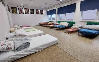 sala z ł&oacute;zkami i materacami dla uchodźc&oacute;w