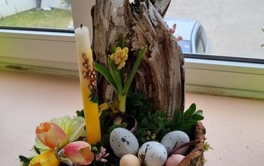 Ozdoba wielkanocna składająca się z drewna, pisanek, trawy