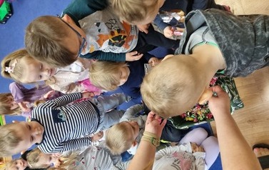 Grupa dzieci pochylona nad torbą z cukierkami