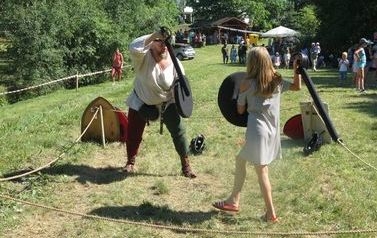 dziewczynka i mężczyzna markują walkę na miecze
