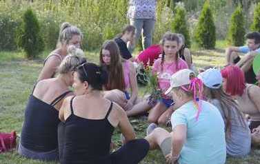 odpoczynek na trawie, wsp&oacute;lne plecenie wiank&oacute;w z polnych kwiat&oacute;w