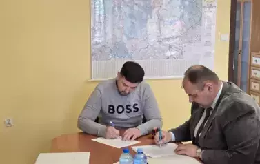 dw&oacute;ch mężczyzn podpisuje dokumenty