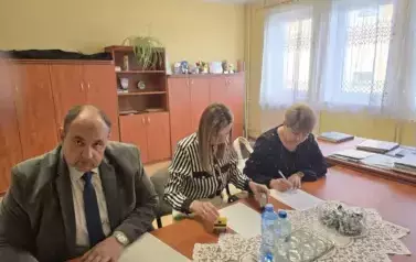 mężczyzna i dwie kobiety podpisują dokumenty