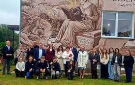 uczestnicy wydarzenia na tle muralu