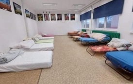 sala z ł&oacute;zkami i materacami dla uchodźc&oacute;w