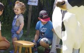 2 dzieci obok sztucznej krowy