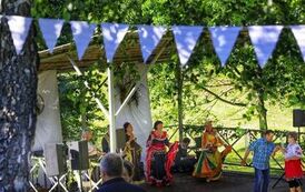 4 kobiety i mężczyzna w strojach cygańskich występują na scenie, para tańczy przed sceną