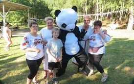 4 kobiety i dziewczynka przy maskotce Pandy