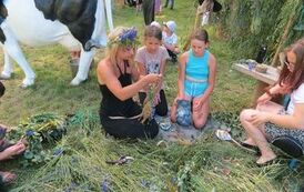 3 dziewczynki i kobieta wyplatają wianki