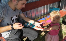 pan Panda maluje wz&oacute;r na ręku dziewczynki