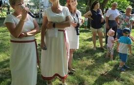 2 panie z zespołu śpiewają podczas wrzucania wiank&oacute;w do wody