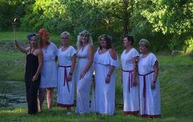 7 pań stojących nad stawem z pochodnią, pracownice ośrodka kultury