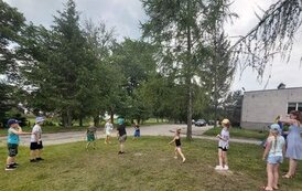 Grupa dzieci bawiąca się na trawie