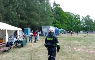 Strażak na tle innych uczestnik&oacute;w imprezy